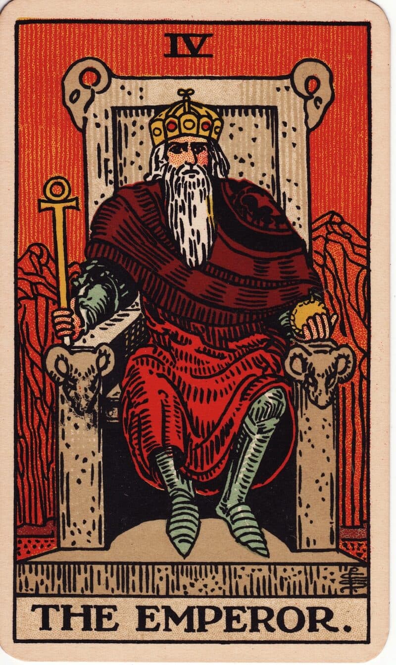 The Emperor tarot card — armored ruler on stone throne with ram-head carvings and ankh scepter, Rider-Waite-Smith deck