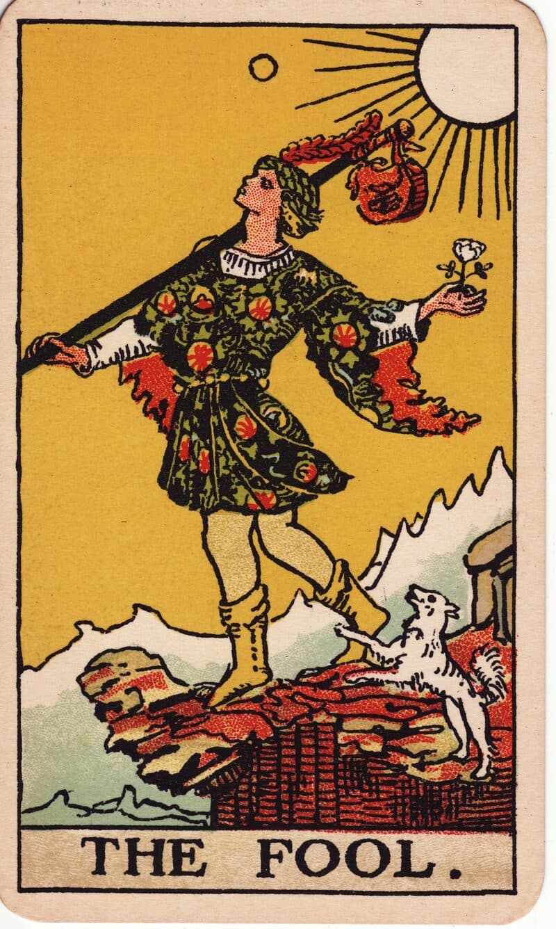 The Fool tarot card — young figure at cliff's edge with white rose and bundle, Rider-Waite-Smith deck