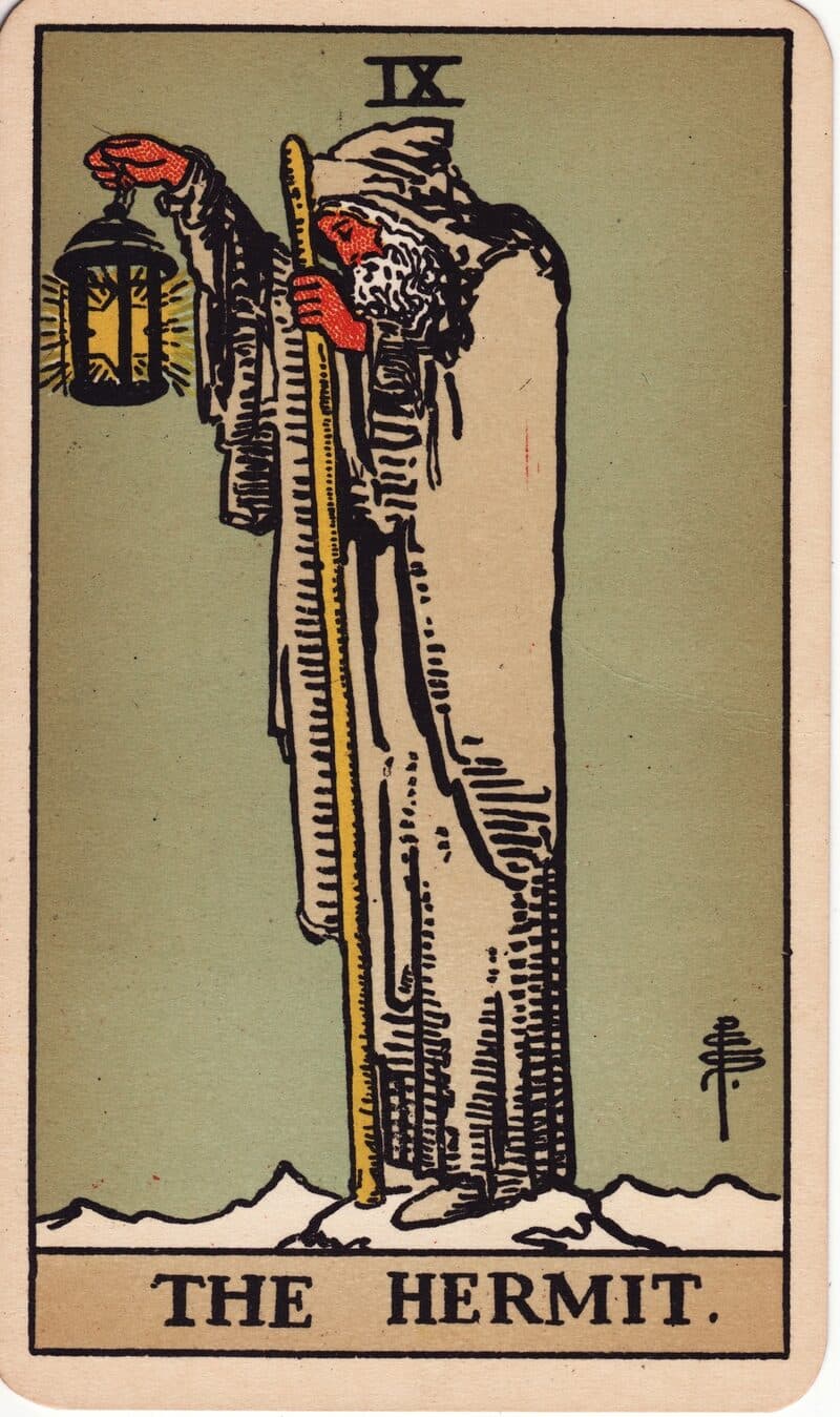 The Hermit tarot card — robed figure on snowy peak holding a lantern with a six-pointed star, Rider-Waite-Smith deck