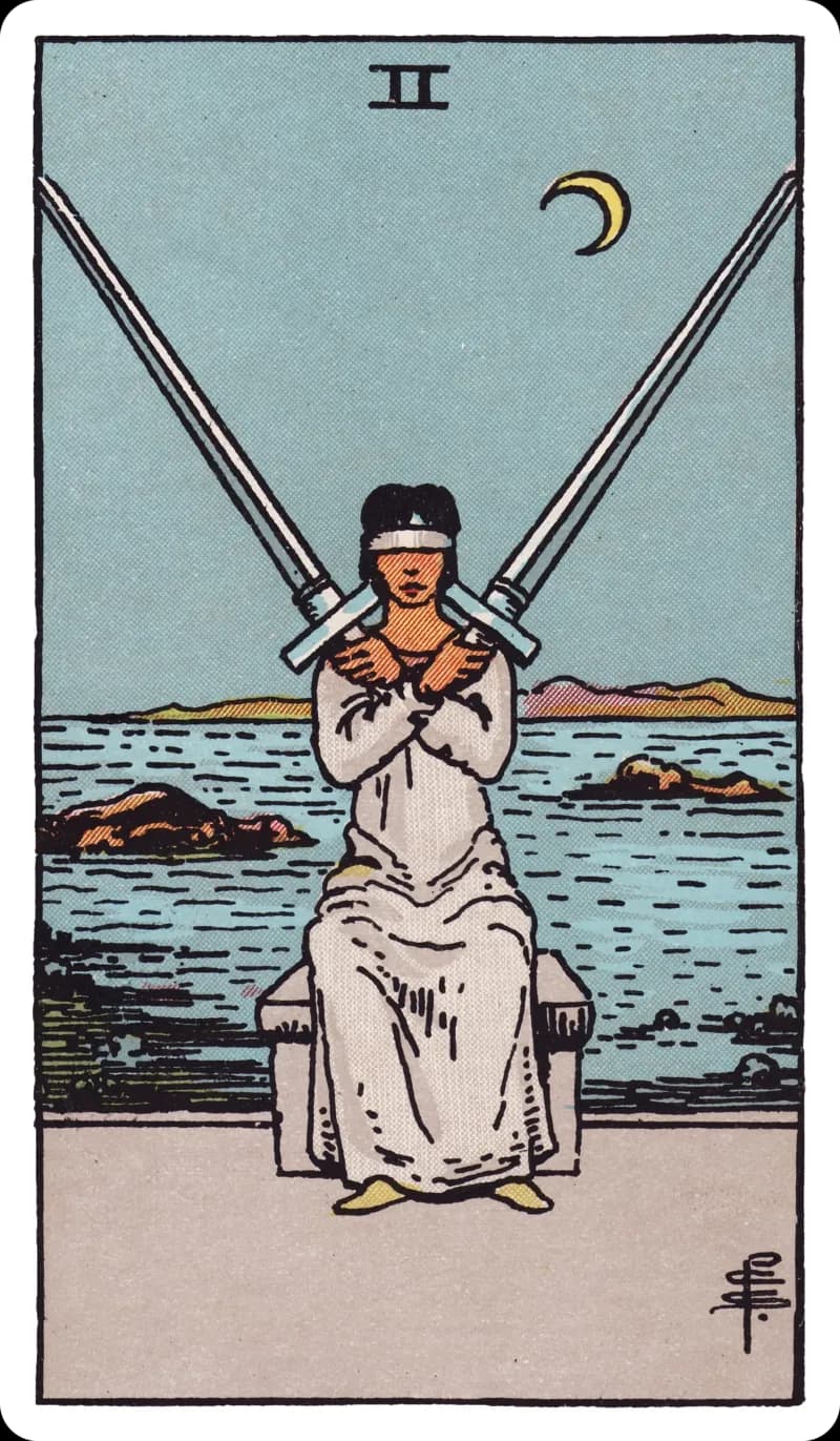 Two of Swords tarot card — blindfolded figure in white with arms crossed balancing a sword in each hand before a calm sea under a crescent moon, Rider-Waite-Smith deck